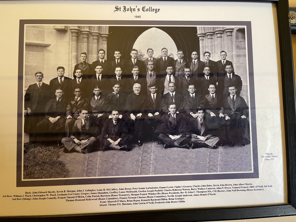 Framed 1940 group photograph of St John's College students in front of a sandstone Gothic archway