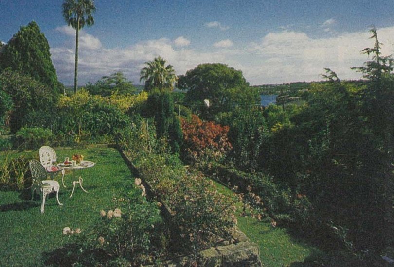 Terraced garden with white garden furniture at 26 Fitzwilliam Road, Vaucluse, looking out towards the harbour