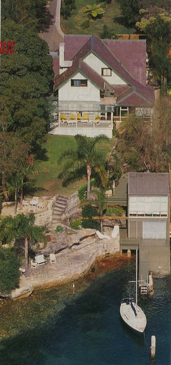 Aerial view of 70 Wentworth Road, Vaucluse: a gabled house above a sandstone foreshore, with a boathouse and jetty