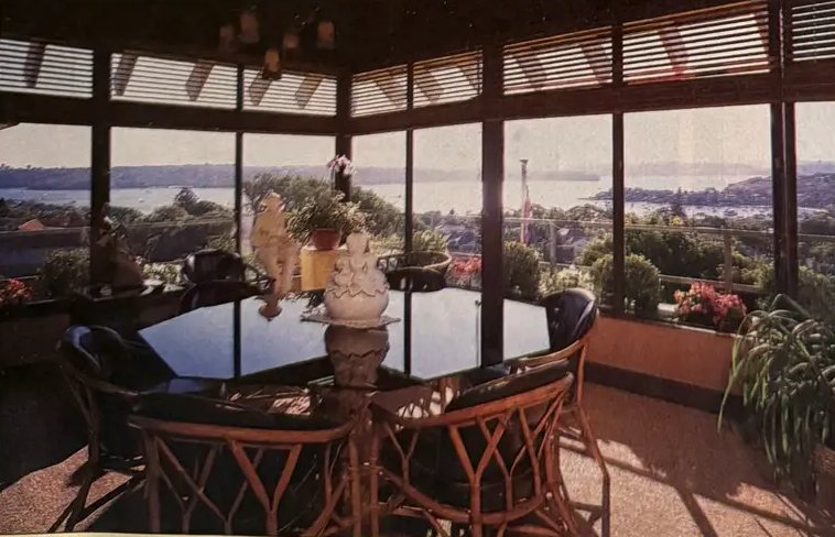 Dining room with tall windows looking out over the harbour at 91 Kings Road, Vaucluse